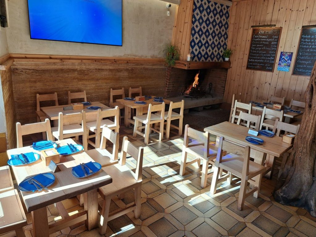 Mesón con mesas de madera rústicas en nuestro restaurante en Madrid, perfecto para una cena o almuerzo en un ambiente auténtico.